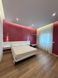 a bedroom with a bed and a red wall at B&B Ciocca II in Campobasso +13 photos