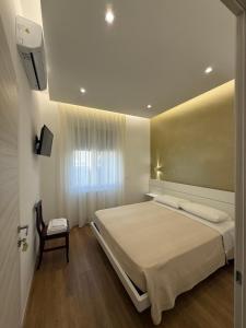 a bedroom with a large bed and a chair at B&B Ciocca II in Campobasso