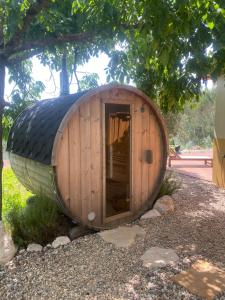 a small wooden hobbit house sitting under a tree at Quinta das Riquezas in Dornes