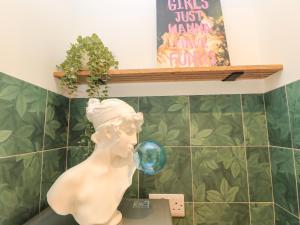 a statue of a woman drinking from a soap bubble at 8 Manor Villas in Totland