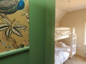 a bedroom with a bed and a green wall at 8 Manor Villas in Totland