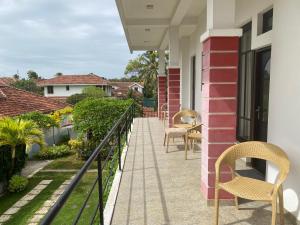 a balcony with chairs and tables on a house at Sea Tide by Jade Rock in Negombo