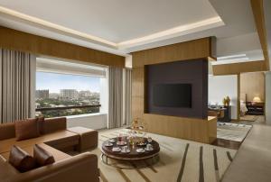 a living room with a couch and a television at Hyatt Regency Chennai in Chennai