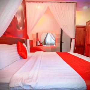a bedroom with a large bed with red and white sheets at Đào Hoa Mộng Couple Hotel - Central & City View in Quy Nhon