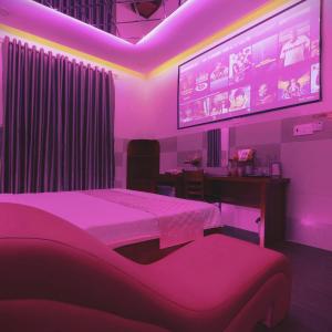 a bedroom with a bed and a projection screen at Đào Hoa Mộng Couple Hotel - Central & City View in Quy Nhon
