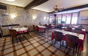 a restaurant with tables and chairs and a brick wall at HOTEL DE LA POMME D'OR in Bar-sur-Aube