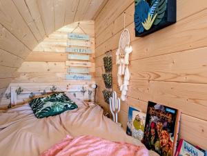 a bedroom with a bed in a wooden wall at Cabane - Nature & Détente in Lavoncourt