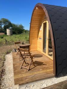 a wooden deck with a table and a tent at Cabane - Nature & Détente in Lavoncourt