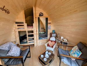 a living room of a log cabin with bunk beds at Cabane - Nature & Détente in Lavoncourt