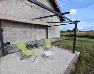 two chairs and a table on a patio at Cabane - Nature & Détente in Lavoncourt +8 photos