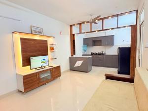 a living room with a television and a kitchen at AeroNest Homes - 1BHK & 2BHK Quiet & Comfortable Near Airport 7km in Muthugadahalli
