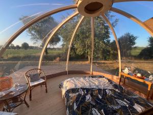 a room with a bed and a table on a deck at Bulle insolite avec spa in Lavoncourt