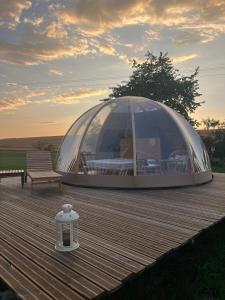 a dome tent on a wooden deck with a bench at Bulle insolite avec spa in Lavoncourt +37 photos