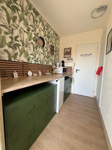a kitchen with green cabinets and a green wall at Bulle insolite avec spa in Lavoncourt