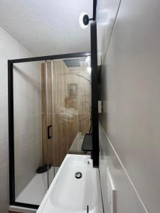 a bathroom with a white sink and a shower at Bulle insolite avec spa in Lavoncourt