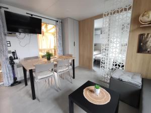 a living room with a table and a dining room at Mobile home à Mimizan géré par un particulier in Mimizan