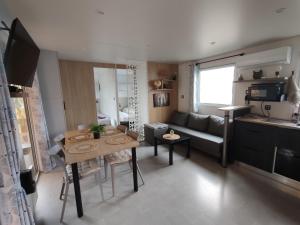 a small living room with a table and a couch at Mobile home à Mimizan géré par un particulier in Mimizan