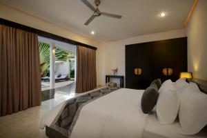 a bedroom with a large bed with a large window at Villa Maharani in Seminyak