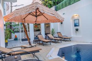 a patio with an umbrella and chairs next to a pool at Siete Hotel in Antalya