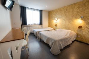 a hotel room with two beds and a window at HOTEL DE LA POMME D'OR in Bar-sur-Aube