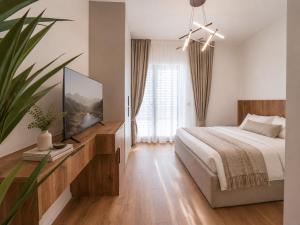 a bedroom with a bed and a flat screen tv at HotelRestaurant Gështenja in Suharekë