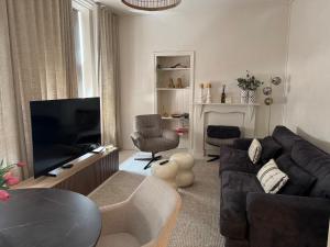 a living room with a couch and a flat screen tv at vakantie appartement D'vine in Valkenburg