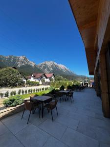 a patio with tables and chairs with mountains in the background at Hotel Restaurant Splendor in Buşteni
