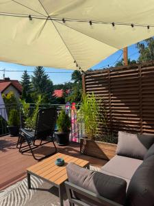 a patio with a couch and an umbrella at Belona in Stegna