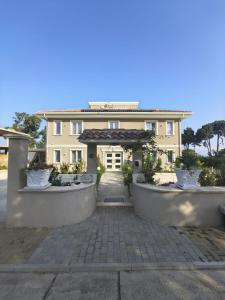 a large yellow building with an umbrella in front of it at Sara B&B Accommodation in Santa Domenica