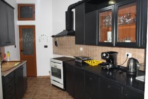 a kitchen with black cabinets and a black counter top at Vila Sosana in Qeparo