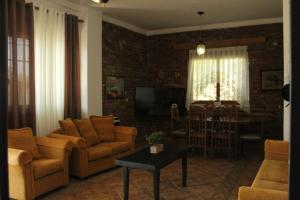 a living room with a couch and chairs and a table at Vila Sosana in Qeparo