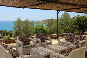 a patio with chairs and a table with a view of the ocean at Vila Sosana in Qeparo