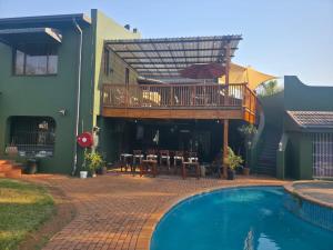 a house with a deck and a swimming pool at Nguni Gaste Huis in Mooinooi