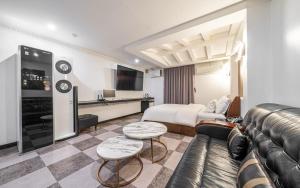 a hotel room with a couch and a bed at Hotel The Fine in Uijeongbu