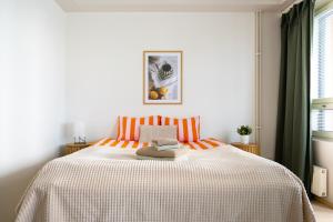a bedroom with a bed with orange and white stripes at Central Studio 33m2 Sauna Wifi Parkkipaikka in Kuusamo