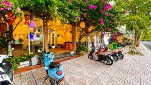 a row of scooters parked in front of a building at Q Song Chi Côn Đảo Hotel in Con Dao