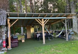 a gazebo with a table and a swing at Glamping Tent Tammemäe in Haapsi