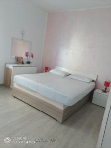 a bedroom with a large bed in a white room at Fortuna in Diano Marina