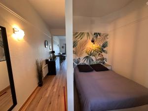 a bedroom with a bed with a mural on the wall at Appartement face mer Le Croisic , piscine privée et plage in Le Croisic