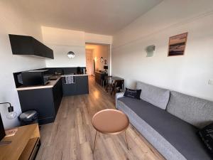 a living room with a couch and a table at Appartement face mer Le Croisic , piscine privée et plage in Le Croisic