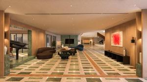 a lobby with a living room with a piano at The Nishat Hotel Margala in Islamabad