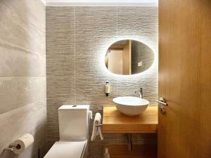 a bathroom with a sink and a toilet and a mirror at Chalet Villas Gerês in Geres