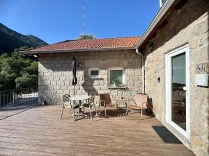 a patio with a table and chairs next to a building at Chalet Villas Gerês in Geres
