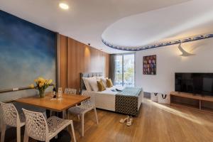 a room with a bed and a table and a television at Club Hotel Eilat - All Suites Hotel in Eilat