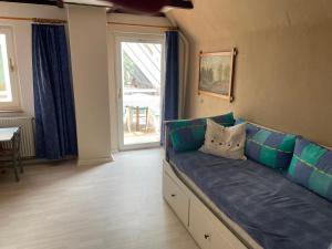 a blue couch in a living room with a window at To Huus bei Hanne 