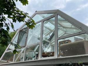 a glass conservatory with a chair in it at To Huus bei Hanne 