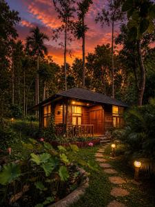 a log cabin in the woods with a sunset at Pugmarks Jungle Resort in Chegāt