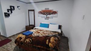 a bedroom with a bed with a tree on the wall at B&B Nuwara eliya in Nuwara Eliya
