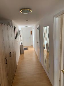 a hallway with wooden cabinets and a hallway with art on the walls at Ferienwohnung Geiseltalsee Frankleben in Frankleben