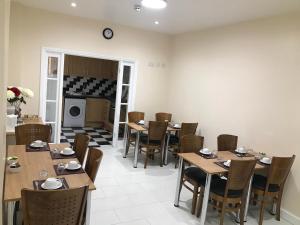 a dining room with tables and chairs and a fireplace at Woodlands Lodge Ilford in Ilford +28 photos